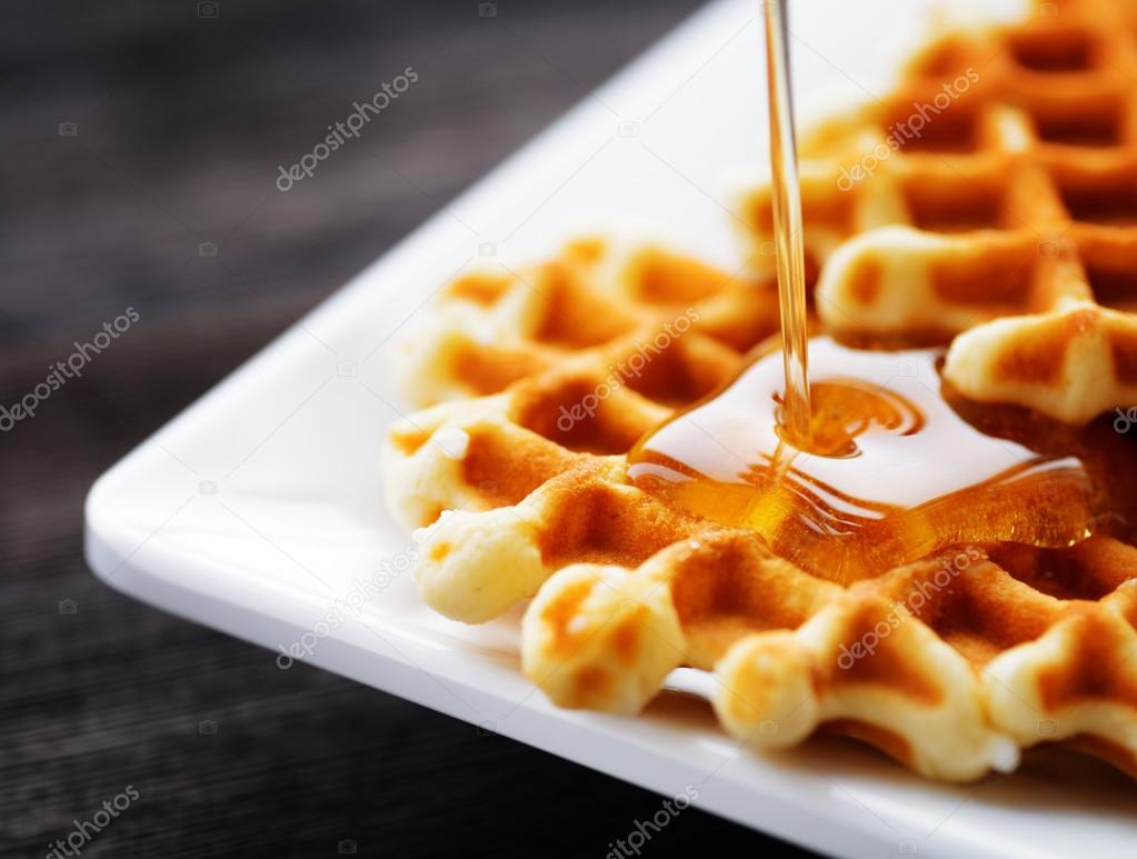 Honey pouring on a fresh waffles