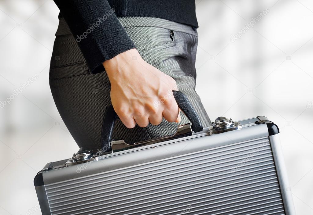 Business woman holding an aluminum briefcase