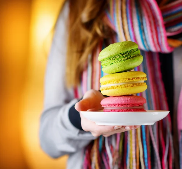 Νέα γυναίκα που κρατά το macaron γαλλικά ζαχαροπλαστικής στο café — Φωτογραφία Αρχείου