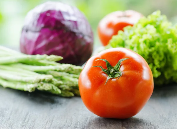 Várias verduras frescas em uma mesa de madeira preta — Fotografia de Stock