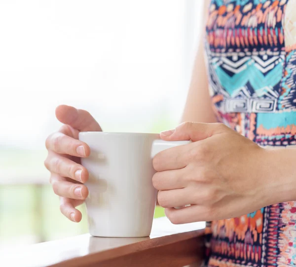 Jonge vrouw genieten van een mok van drank. — Stockfoto