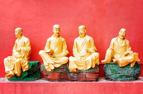 Golden Buddha statues outside the temple with red wall in the ba — Stock Photo, Image