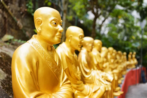 Zlatými sochami Buddhy a krajina se zelenými stromy — Stock fotografie