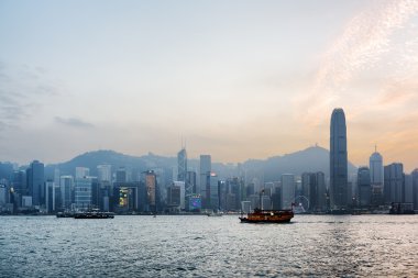 Hong Kong şehir ve Victoria Harbor batımında tekne görünümü