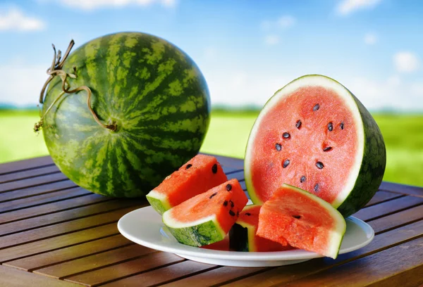 Färsk mogen vattenmelon på ett träbord — Stockfoto