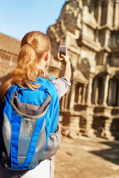 Женщина-туристка со смартфоном фотографируется в храме Ангкор — стоковое фото
