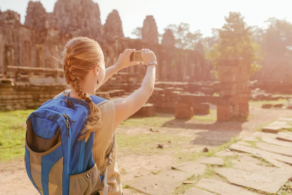 Female tourist with smartphone taking picture in Angkor Thom — Stock Photo, Image