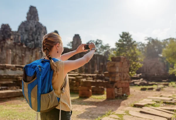 Jonge vrouwelijke toerist met smartphone in Bayon tempel, Angkor — Stockfoto