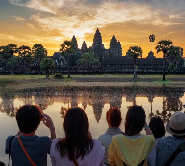 Turistas asiáticos tirando fotos de Angkor Wat ao nascer do sol — Fotografia de Stock