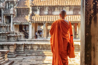 Buddhist monk looking at courtyard of Angkor Wat, Cambodia