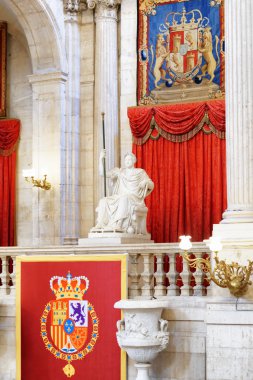 The coat of arms of the King of Spain and a sculpture in the int