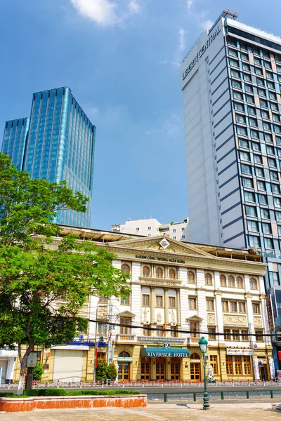 Ho Chi Minh, Vietnam - 30 April 2015: Kontrast av modern och gammal arkitektur av byggnader i Ho Chi Minh city. Hotell på blå himmel bakgrund. Ho Chi Minh är ett populärt turistmål i Asien. — Stockfoto