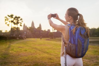 Genç kadın turist alarak resim Wat Angkor Kamboçya'da