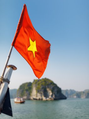 The flag of Vietnam fluttering on ship, the Ha Long Bay clipart