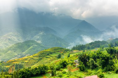 Scenic view of rays of sunlight through clouds in mountains