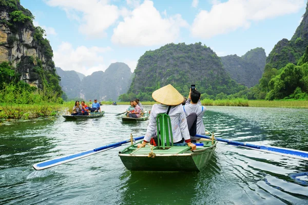 Tourists in boats. Rowers using feet to propel oars, Vietnam — Stock Fotó