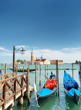 Gondolas parked at pier beside the Riva degli Schiavoni, Venice