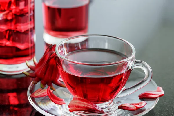 Cup of magenta hibiscus tea (rosella, karkade) on table — Stockfoto