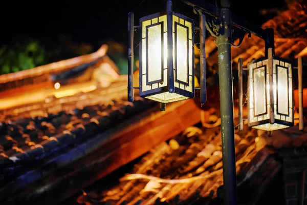 Night view of street lamp and traditional Chinese tile roofs — Stock Fotó