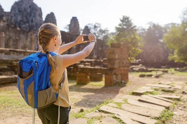 Young female tourist with smartphone in Angkor Thom — Stok fotoğraf