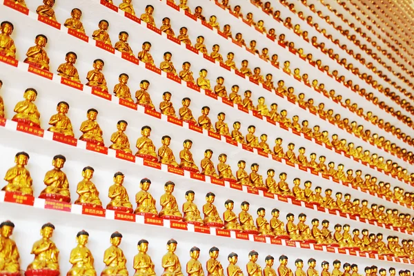 Pared con pequeñas estatuas doradas de Buda dentro del templo de la T —  Fotos de Stock
