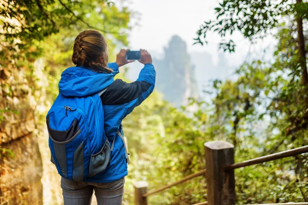 Joven turista femenina tomando fotos de hermosas vistas a la montaña —  Fotos de Stock