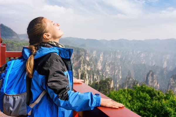 Fiatal női turista élvezi a napfényt és hegyre néző kilátással — Stock Fotó