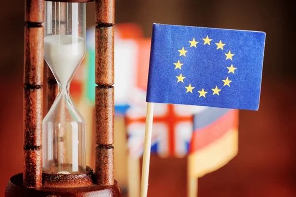 Κλεψύδρα και σημαία της Ευρωπαϊκής Ένωσης. Χρόνος εξαντλείται — Φωτογραφία Αρχείου