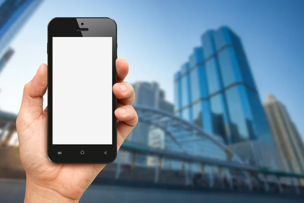 Mano con schermo bianco smartphone con ufficio buiding backgr — Foto Stock
