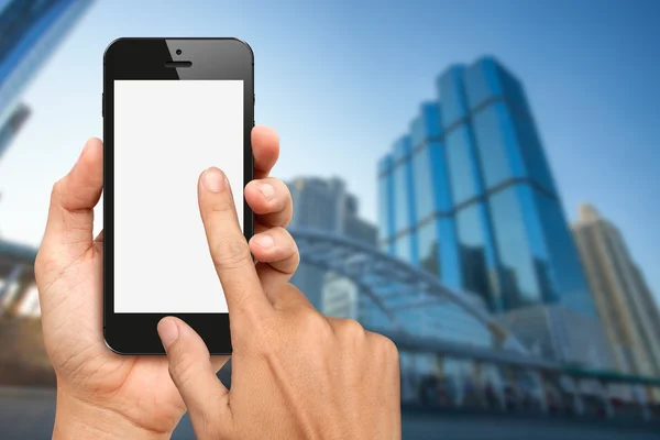 Mani tenere e toccare smartphone con sfondo buiding ufficio — Foto Stock