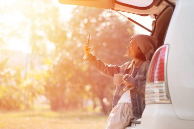 Arabayla seyahat eden bir kadın. Sabah kahve fincanıyla dinleniyor.