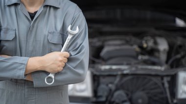 İngiliz anahtarı olan bir araba tamircisi. Otomatik tamir garajı.
