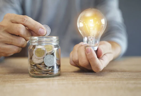 手はコインスタックと電球を保持 お金の概念を救うための創造的なアイデア 将来のマネジメント — ストック写真