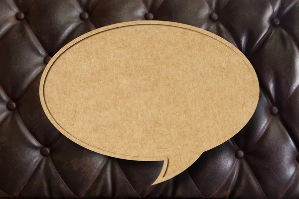 Recycle paper speech bubble on leather upholstery background — Stock Photo, Image