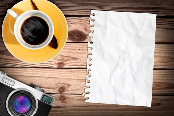 Leeres Papier auf Holztisch mit Kaffee und klassischer Kamera — Stockfoto