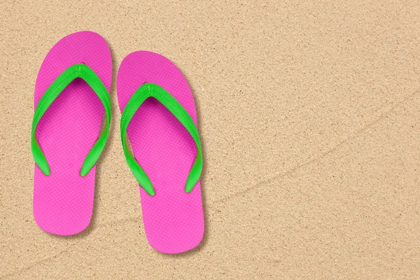 Roze en groen slippers op het strand met ruimte — Stockfoto