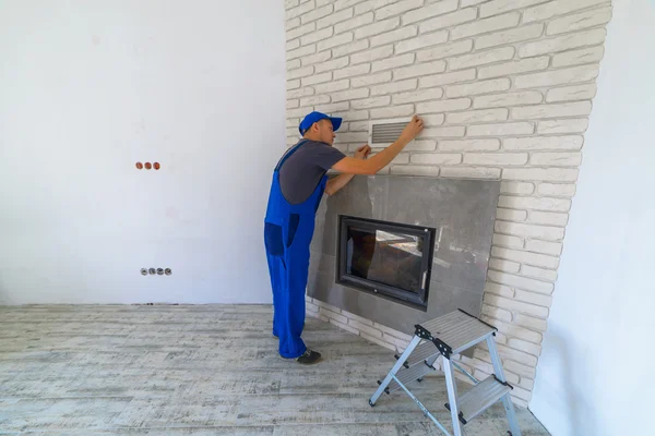 Worker Installing Fireplace White Brick Wall — Stock Photo, Image