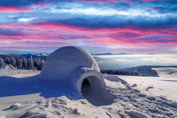 Ekte snøigloo om vinteren. Fjellene gløder om kvelden. – stockfoto