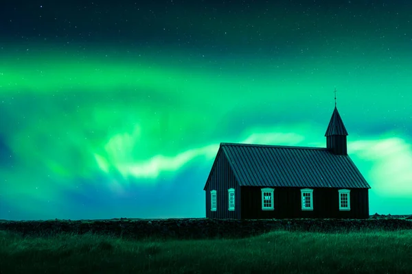 Aurora borealis severní světla nad slavným malebným černým kostelem — Stock fotografie