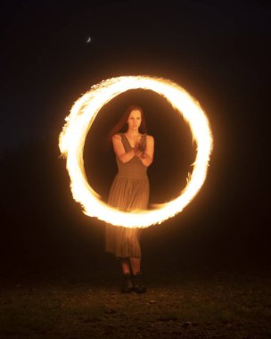Zarif kızıl saçlı kadın ateş sanatçısı.