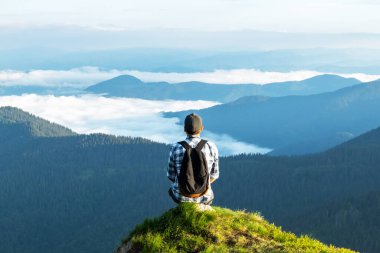 Bir turist uçurumun kenarında oturur.
