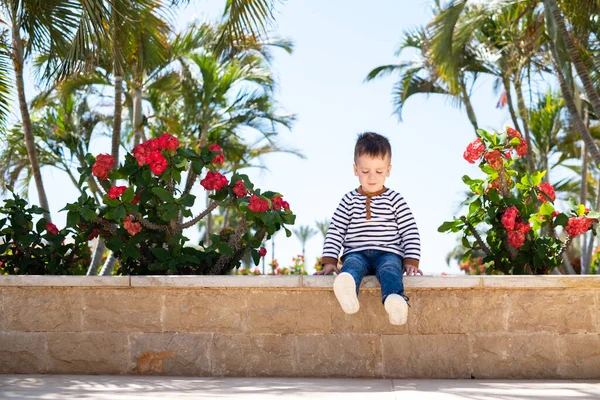 Menino sentado no banco no parque — Fotografia de Stock