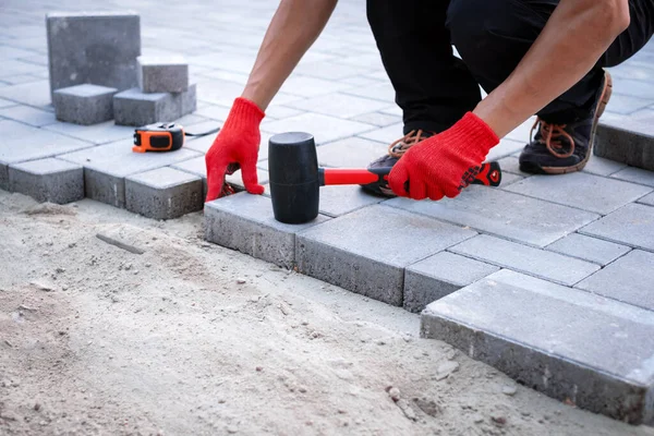 The master in yellow gloves lays paving stones — Stock Photo, Image