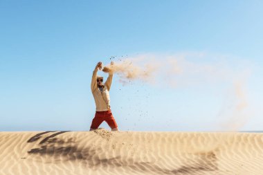 Bekar adam Namib çölüne kum atıyor.