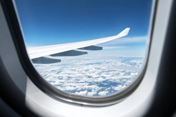 View of clouds and wing from a plane window — Stock Photo, Image