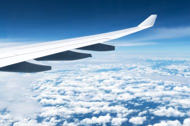 Bir uçak penceresinden bulutların ve kanadın görüntüsü