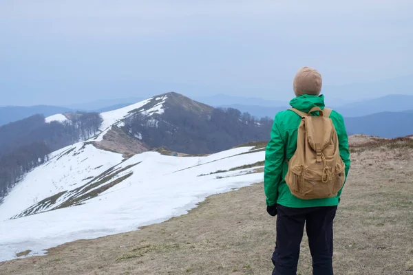 Toerist met rugzak in besneeuwde bergen — Stockfoto