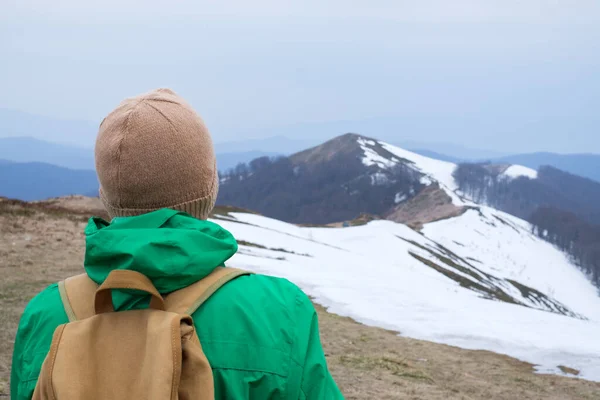 Turysta z plecakiem w śnieżnych górach — Zdjęcie stockowe