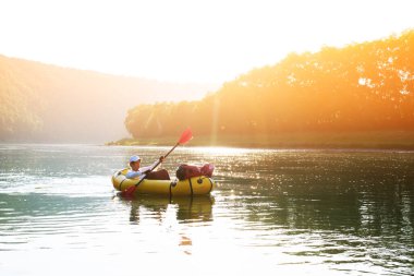 Sarı yük gemisindeki turist kırmızı yüzgeçli lastik bot