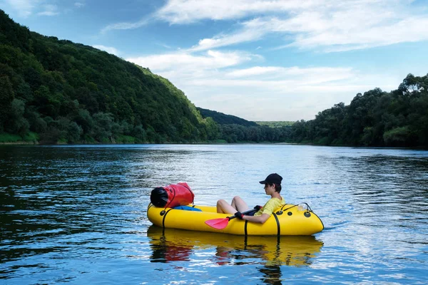 Turist på gul packraft gummibåt med röd paddel — Stockfoto